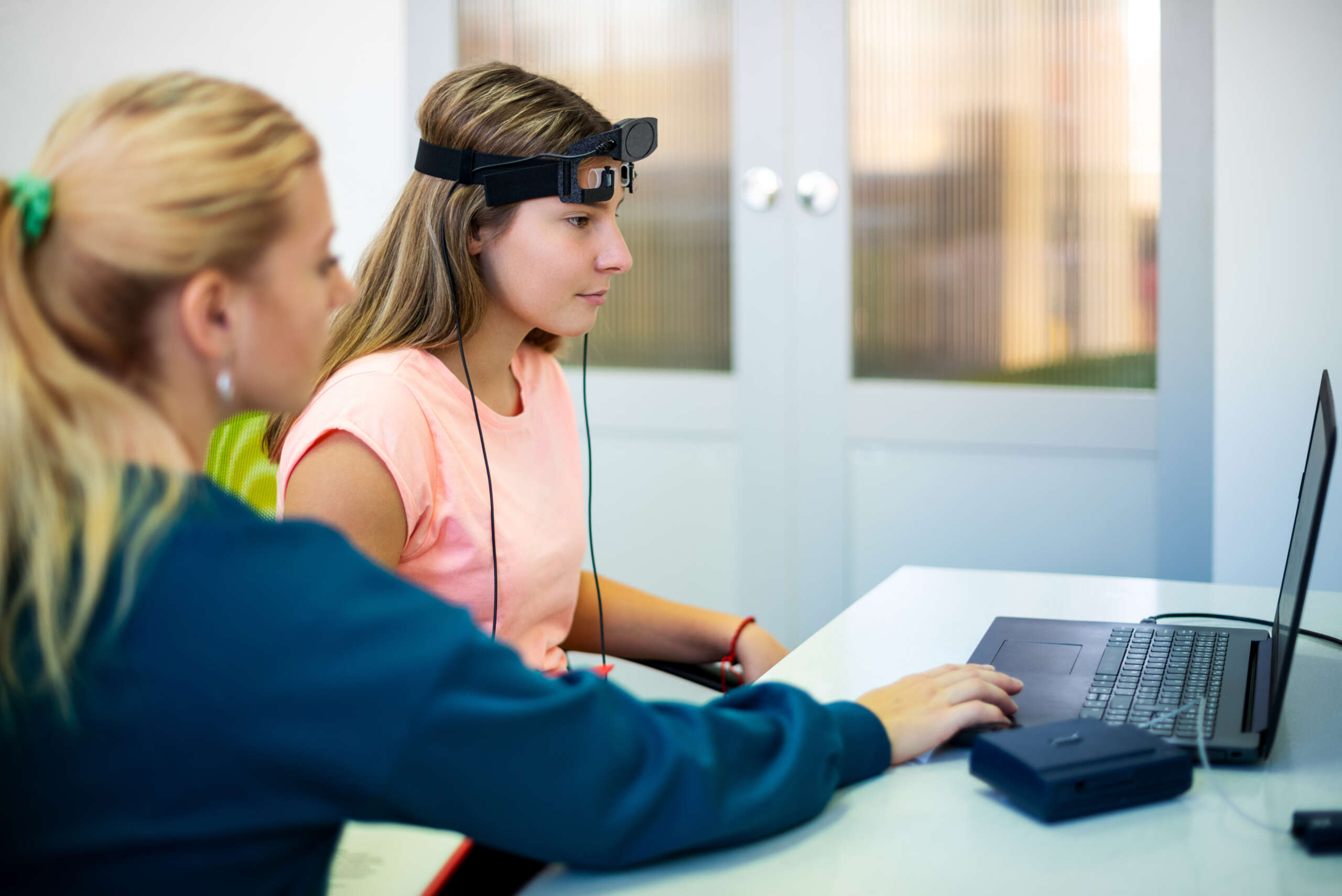 Young,Teenage,Girl,And,Child,Therapist,During,Eeg,Neurofeedback,Session.